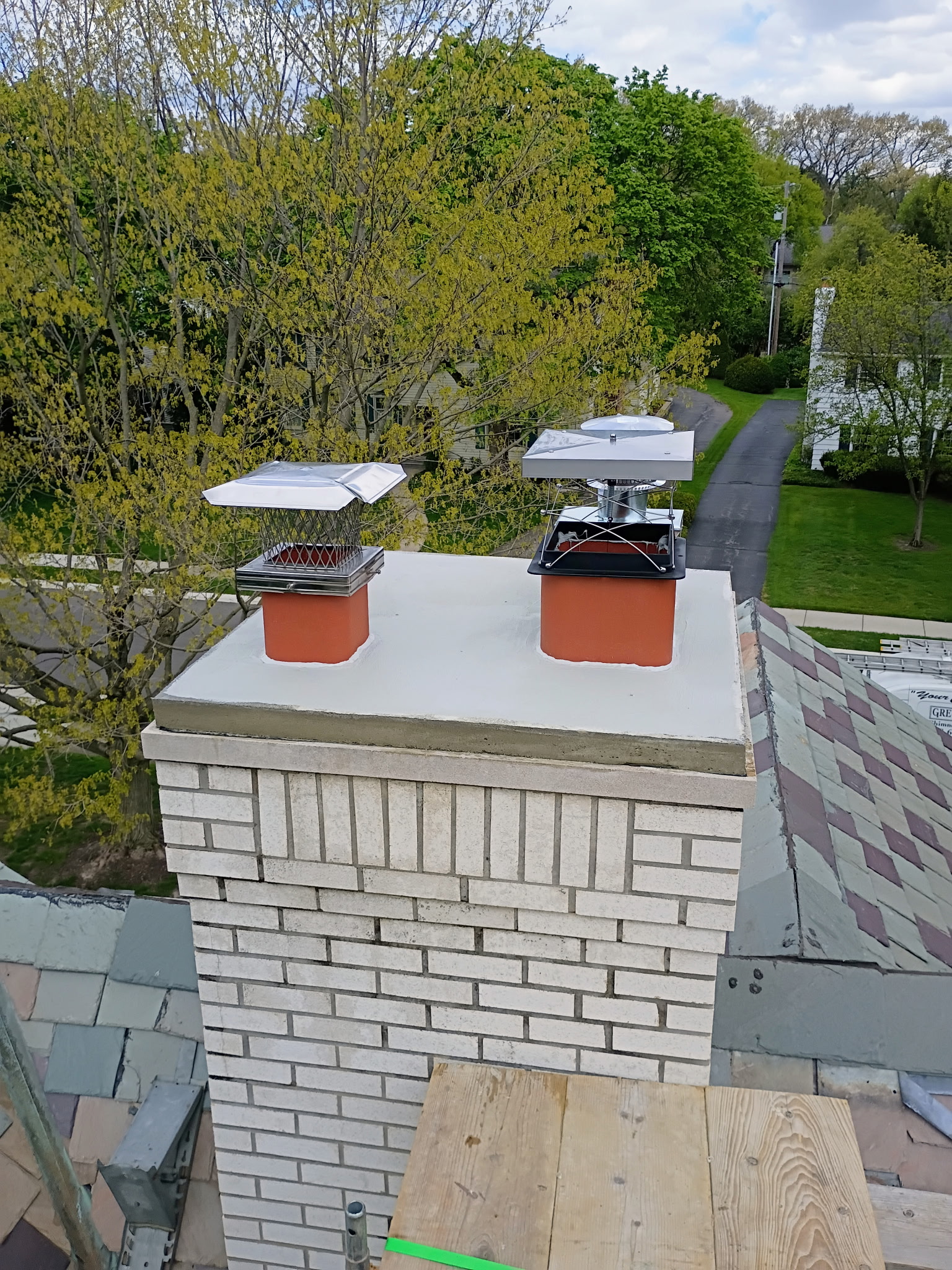 White brick chimney with new stainless caps