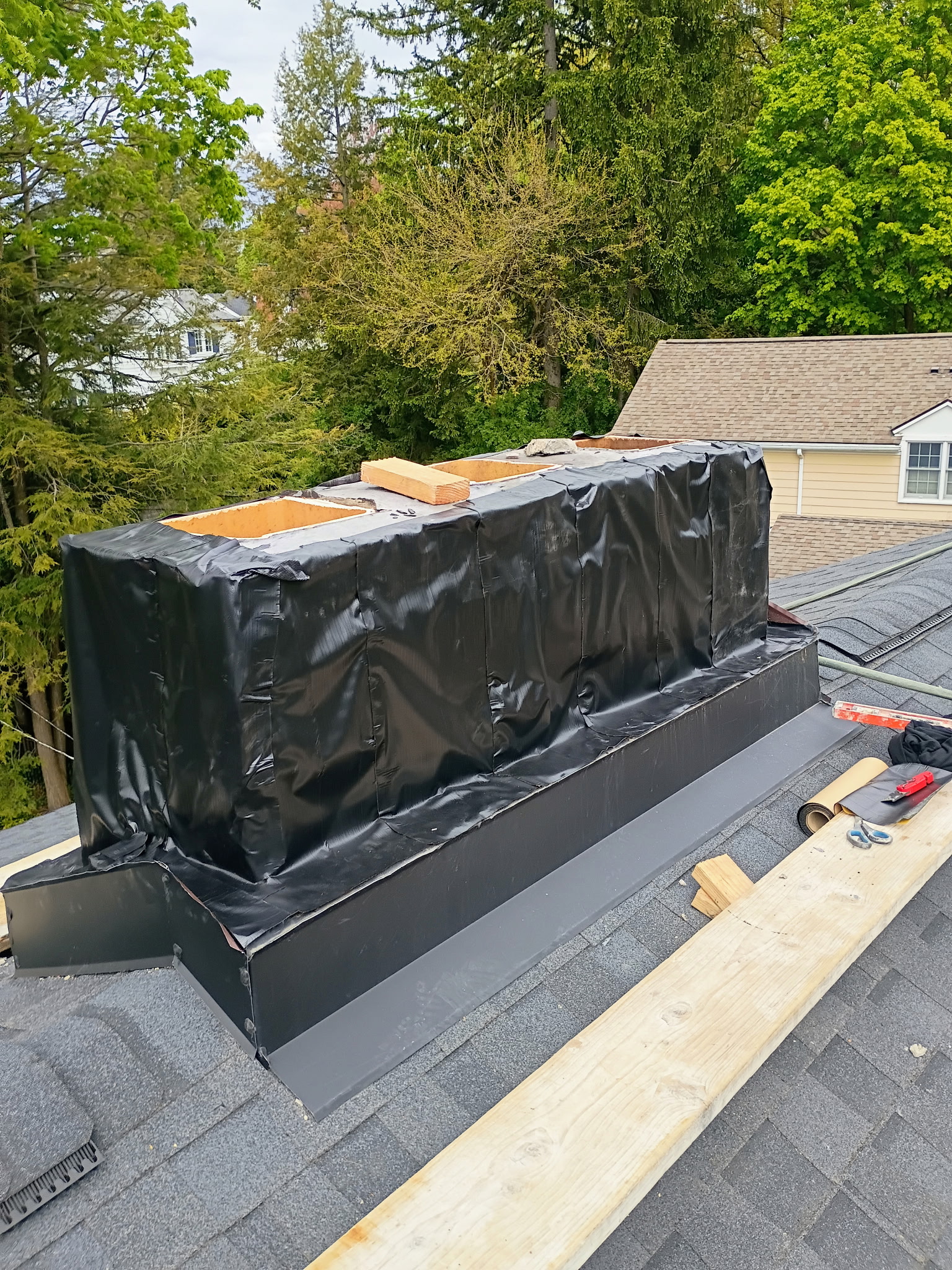 Chimney wrapped in waterproofing during full rebuild