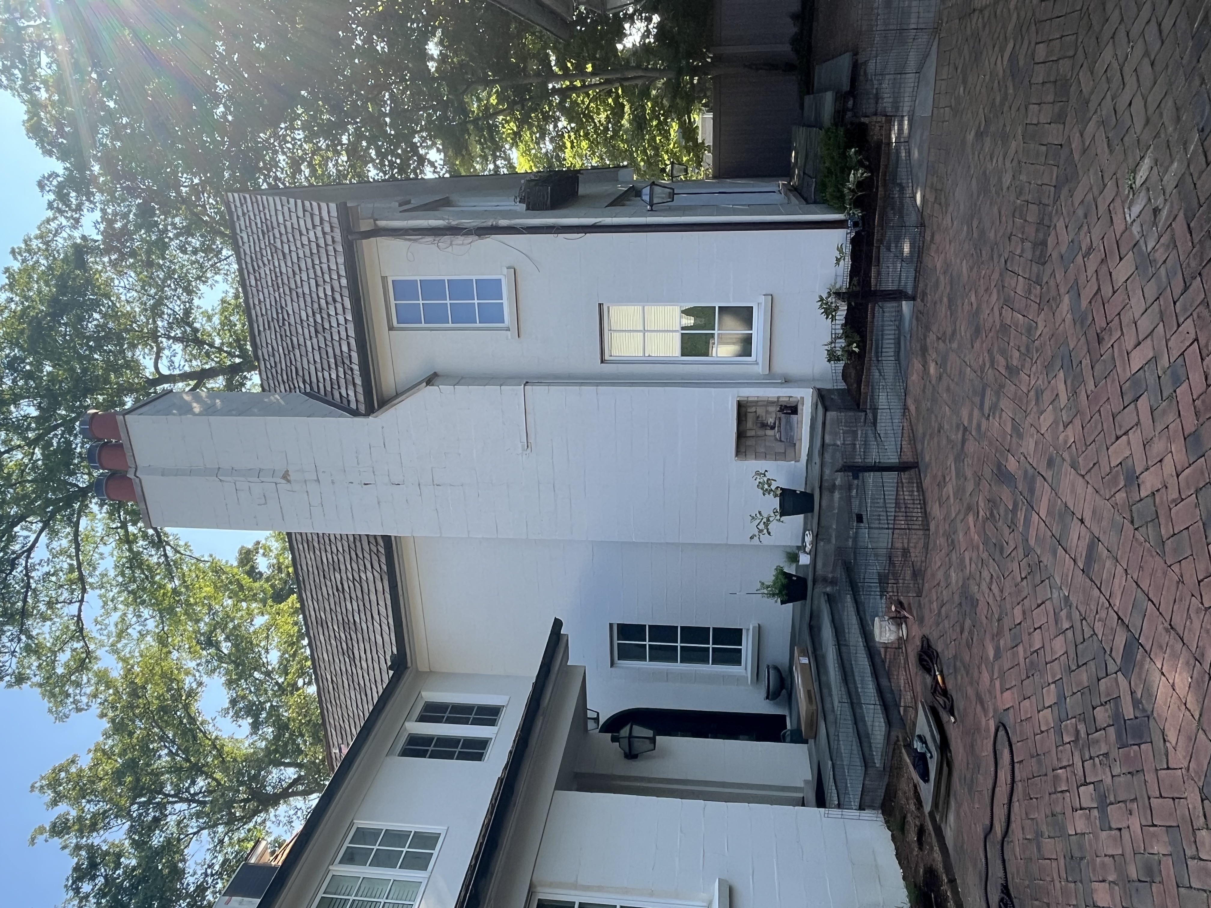 Chimney on luxury home with brick driveway